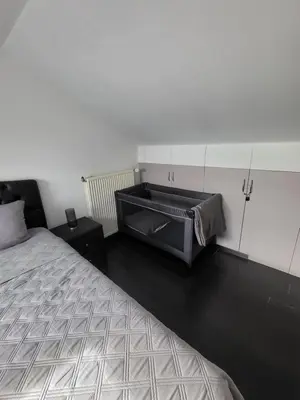 a bedroom with a bed and a dresser in it at Le gîte des Ambres in Denderleeuw