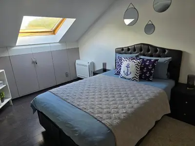 a bedroom with a large bed and a window at Le gîte des Ambres in Denderleeuw