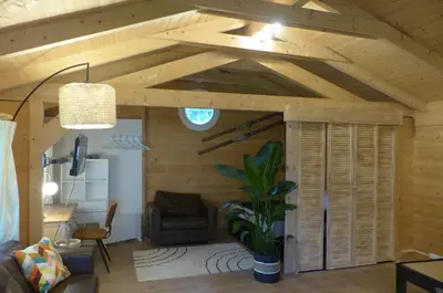 a living room with a wooden ceiling with a couch and a chair at Wood-and-work in Wavre