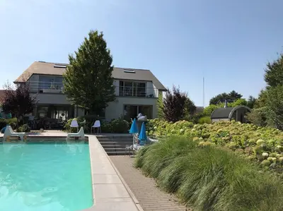 a house with a swimming pool in front of a house at Vakantievilla met zwembad, wellness en glamping in Paal/Beringen in Beringen