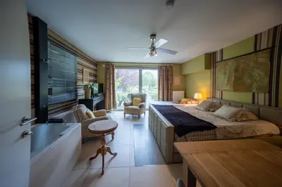 a bedroom with a large bed and a bathroom at Vakantievilla met zwembad, wellness en glamping in Paal/Beringen in Beringen