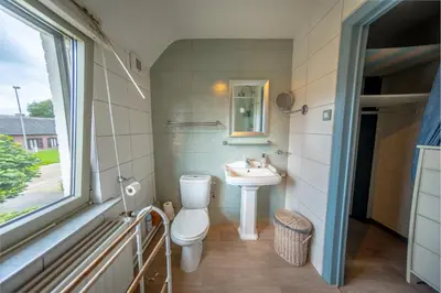 a bathroom with a toilet and a sink and a window at Vakantievilla met zwembad, wellness en glamping in Paal/Beringen in Beringen