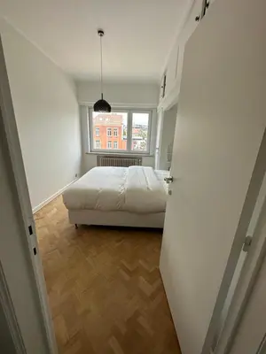 a bedroom with a bed and a window at Cosy apartment with park view in Ghent