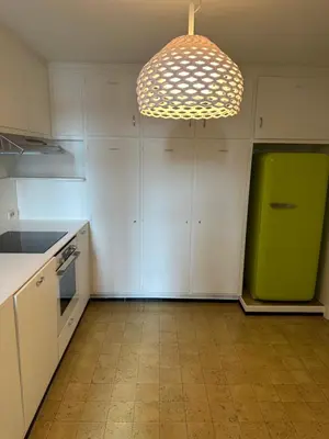a kitchen with white cabinets and a green refrigerator at Cosy apartment with park view in Ghent