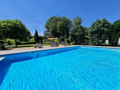 a large swimming pool with blue water at Parkhoeve Vakantiewoning voor 21 personen in Ham