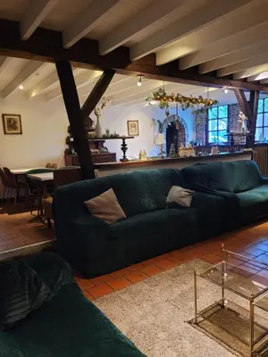 a living room with a green couch and a table at Parkhoeve Vakantiewoning voor 21 personen in Ham