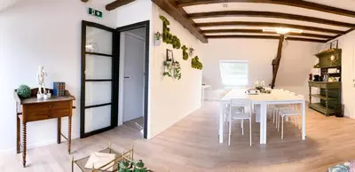 a dining room with a white table and chairs at Parkhoeve Vakantiewoning voor 21 personen in Ham