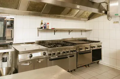 a kitchen with a stainless steel stove top oven at Parkhoeve Vakantiewoning voor 21 personen in Ham