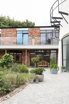 a brick building with plants in front of it at Brand New Apartment Sint-niklaas in Sint-Niklaas