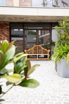 a patio with a bench and some plants at Brand New Apartment Sint-niklaas in Sint-Niklaas