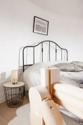a white bedroom with a bed and a table at The Millhouse in Sint-Niklaas