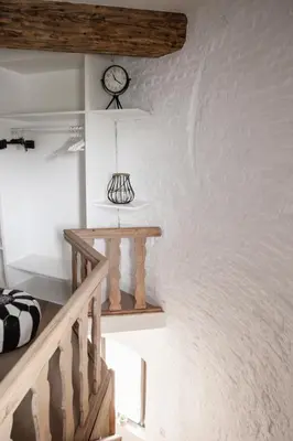 a room with a staircase and a clock on the wall at The Millhouse in Sint-Niklaas