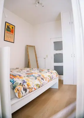 a bedroom with a bed with a colorful quilt at Appartement vlakbij Antwerpen centrum! in Antwerp
