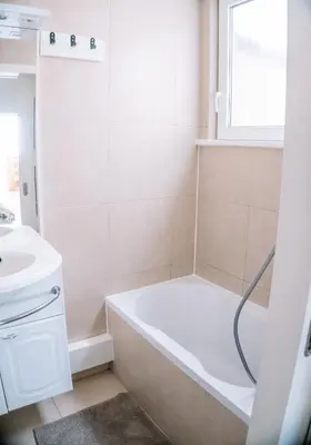 a white bathroom with a tub and a sink at Appartement vlakbij Antwerpen centrum! in Antwerp