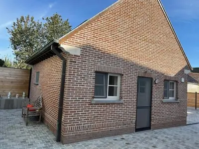 a brick building with a bench and a window at Duivenboshuisje in Herzele