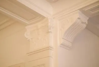 a close up of a white wall with ornate ceilings at Your homestay in a bibliophile mansion in Antwerp