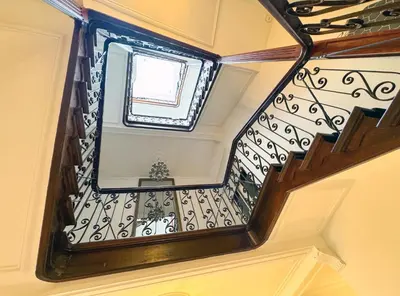 a spiral staircase with a window in a building at Your homestay in a bibliophile mansion in Antwerp