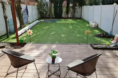 a patio with two chairs and a table in a yard at Lux & Cozy Apt + Garden +Jaccuzi in Antwerp