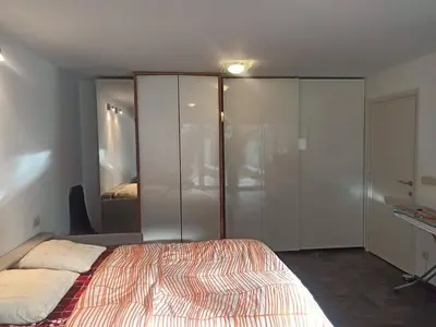 a bedroom with a large bed and a closet at Lux & Cozy Apt + Garden +Jaccuzi in Antwerp