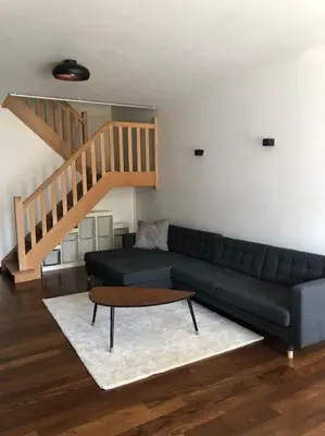 a living room with a couch and a staircase at Central Oasis near Brussels / Airport in Kortenberg