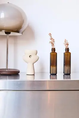 a table with three vases and a lamp on it at The Banker Antwerpen - Free Parking in Antwerp
