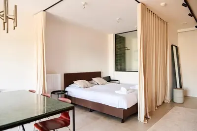 a bedroom with a bed and a dining table at The Banker Antwerpen - Free Parking in Antwerp