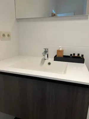 a bathroom counter with a white sink and a mirror at K&Y suites 2 Brussels airport 500m! in Zaventem