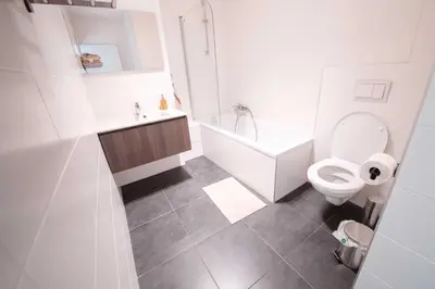 a bathroom with a toilet and a tub and a sink at K&Y suites 2 Brussels airport 500m! in Zaventem