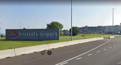 a sign for a business airport on the side of a road at K&Y suites 2 Brussels airport 500m! in Zaventem