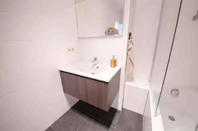 a white bathroom with a sink and a shower at K&Y suites 2 Brussels airport 500m! in Zaventem