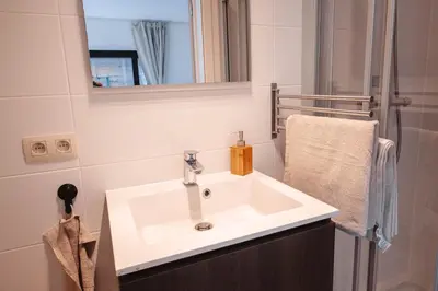 a bathroom with a white sink and a mirror at K&Y suites 3 Brussels airport 500m! in Zaventem