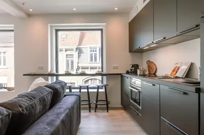a living room with a couch and a kitchen at Margriet Apart-Suites in Ghent