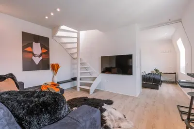 a living room with a couch and a staircase at Margriet Apart-Suites in Ghent