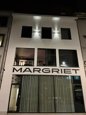 a white building with a mercet sign on it at Margriet Apart-Suites in Ghent