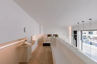 a bedroom with white walls and a bed and a window at Margriet Apart-Suites in Ghent