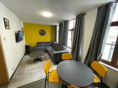 a living room with a couch and a table and chairs at Apartament duplex in Brussels