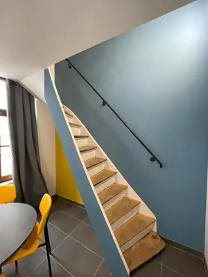 a staircase in a room with a blue wall at Apartament duplex in Brussels