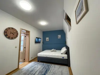a bedroom with a bed and a clock on the wall at Apartament duplex in Brussels
