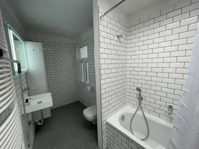 a white bathroom with a tub and a toilet at Apartament duplex in Brussels