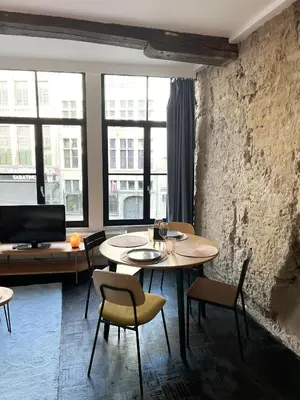 a dining room with a table and chairs and windows at Cosy Appartement Nammos 1 - 4 p in Antwerp