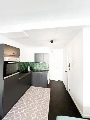 a kitchen with gray cabinets and white appliances at Cosy Appartement Nammos 1 - 4 p in Antwerp