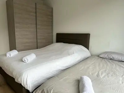 two beds in a bedroom with white sheets and pillows at Furnished 2 Bedroom Apartment in City Center in Brussels