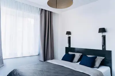 a bedroom with a large bed with blue pillows at Atomihotel: Contemporary Comfort Steps from the Atomium! in Brussels