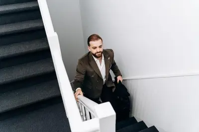 a man in a suit sitting on the stairs at Atomihotel: Contemporary Comfort Steps from the Atomium! in Brussels