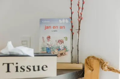a book sitting on top of a shelf next to a box at ScraB&Ble Ecologische gastenkamers in Bornem