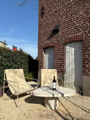 a bottle of wine sitting on a table next to a brick building at B&B deZwarteFles in Ghent