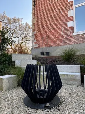 a black sculpture sitting in front of a brick building at B&B deZwarteFles in Ghent