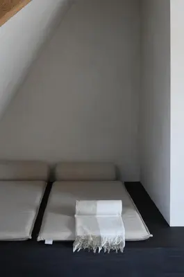 a bed with a white blanket on it in a room at B&B deZwarteFles in Ghent