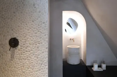 a bathroom with a shower with a stone wall at B&B deZwarteFles in Ghent