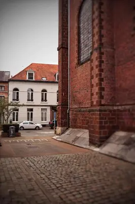 a brick building with a car parked in a parking lot at Casa della Nonna in Diest